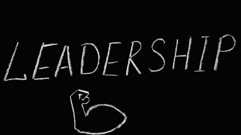 Chalkboard art showcasing the word 'Leadership' and a drawn muscle symbolizing strength.